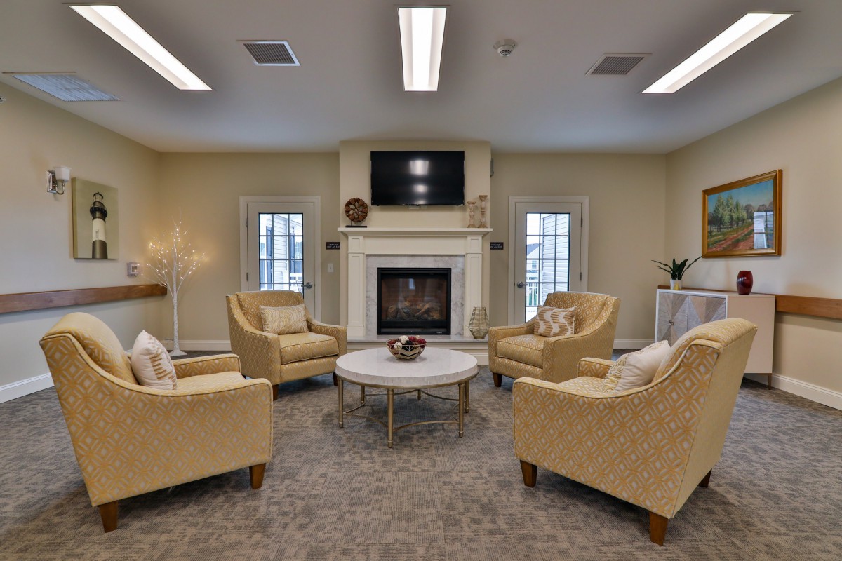 A cozy living room with elegant armchairs arranged around a fireplace and a coffee table.