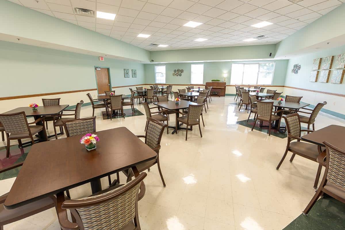 An empty dining room with neatly arranged tables and chairs.