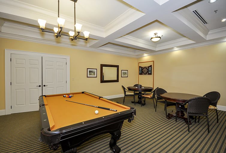 A well-lit game room featuring a pool table and seating area.