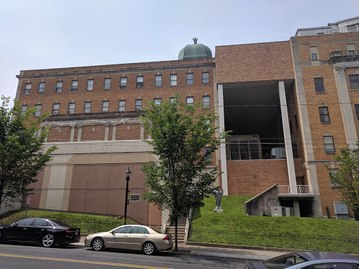 A brick building with a dome structure, seen from the street.