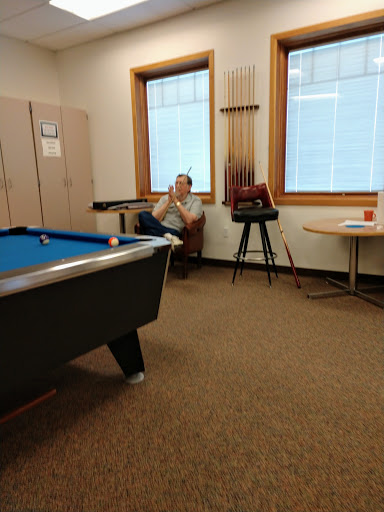 A quiet moment in a recreational room featuring a pool table and a person relaxing.