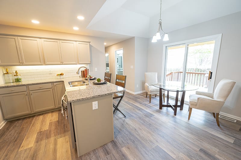 A modern kitchen and dining area with an open layout, featuring ample natural light and contemporary design elements.