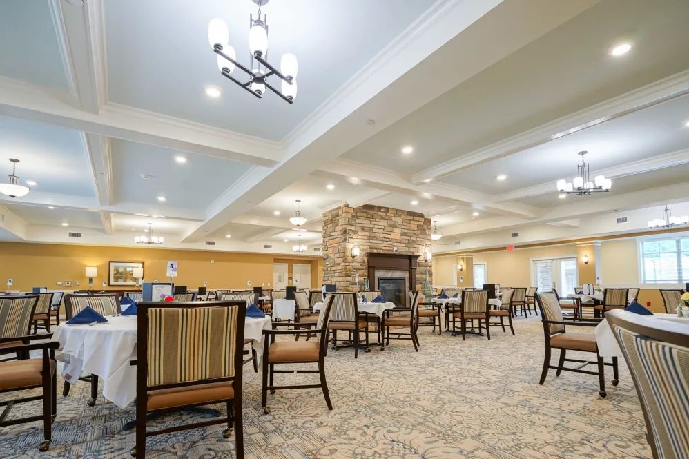 A spacious dining area with elegant furniture, ambient lighting, and a cozy fireplace.