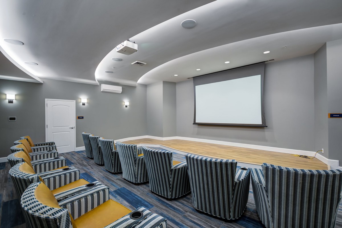 A modern home theater with striped seating and a large projector screen.