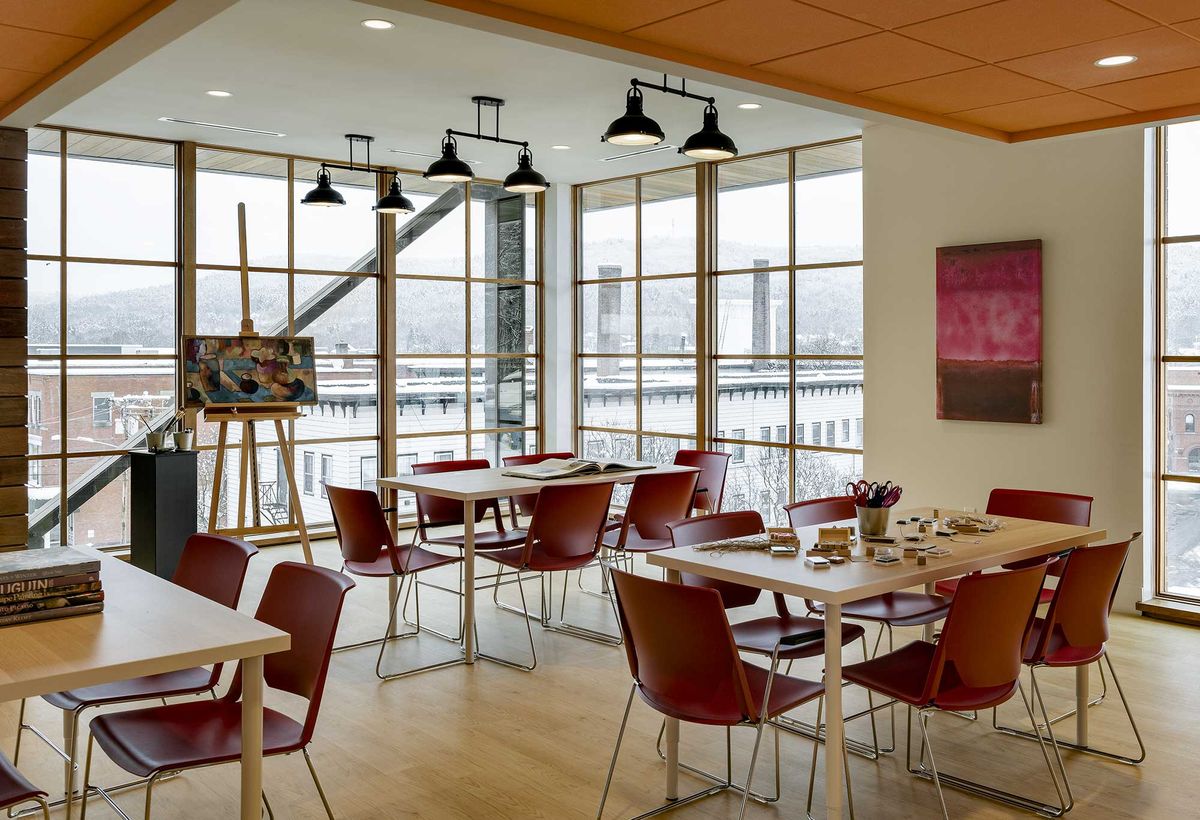 A modern cafe interior with large windows and artwork on display.