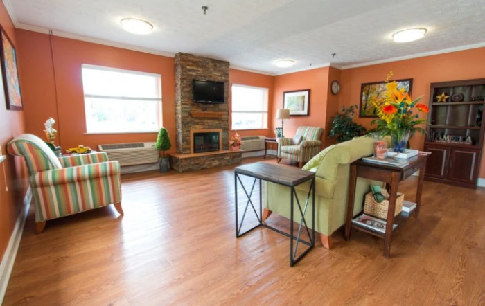 A cozy living room with a fireplace, comfortable seating, and warm decor.