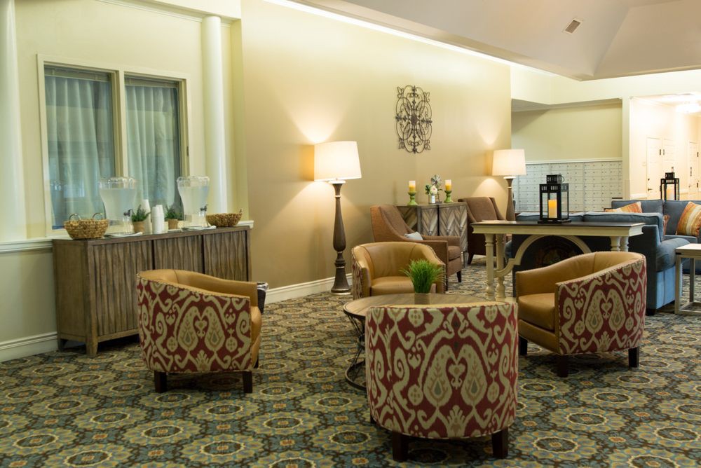 A cozy hotel lobby with patterned chairs, a round table, and ambient lighting.