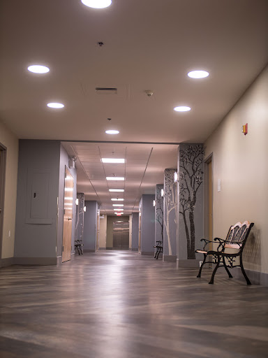 A well-lit, modern hallway featuring a bench and contemporary decor.