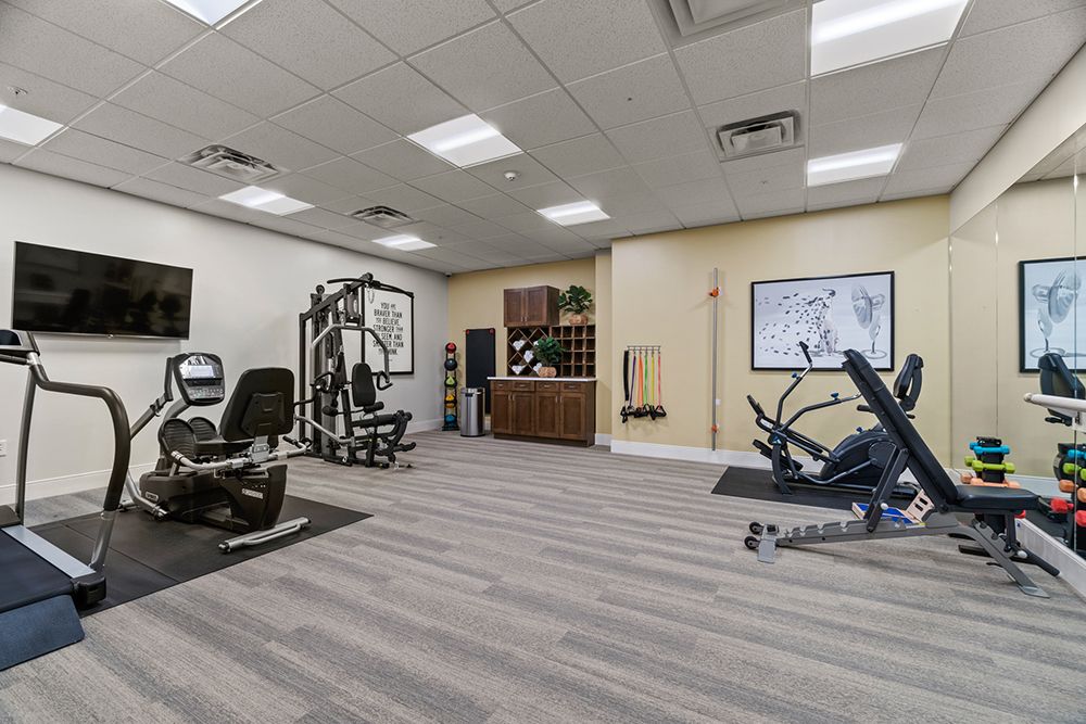 A modern gym with various exercise equipment and a clean interior.