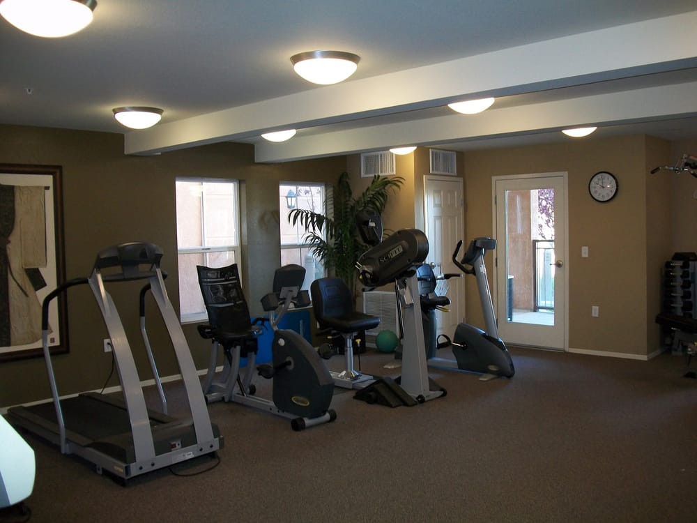 A small indoor gym with various exercise machines including treadmills and stationary bikes.