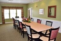 A well-lit meeting room with a long conference table and chairs in an office setting.