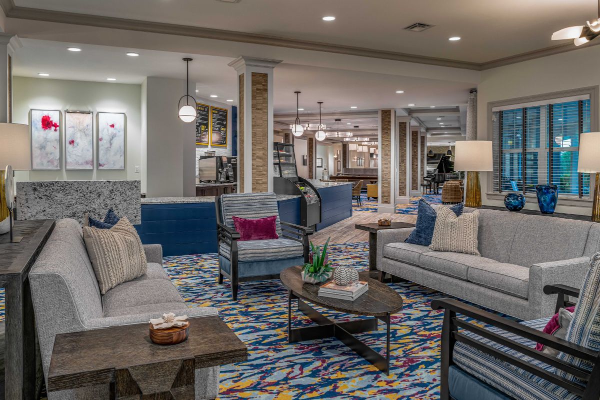 A modern lobby area featuring comfortable sofas, a colorful carpet, and stylish lighting.