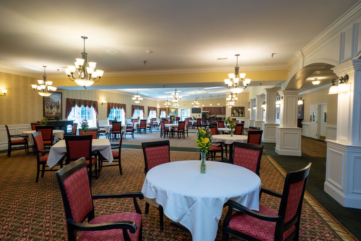A spacious dining area with elegant lighting and neatly arranged tables.