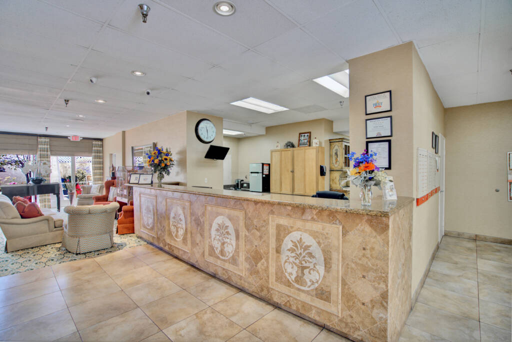A well-decorated reception area with a stone-front desk and a waiting area.