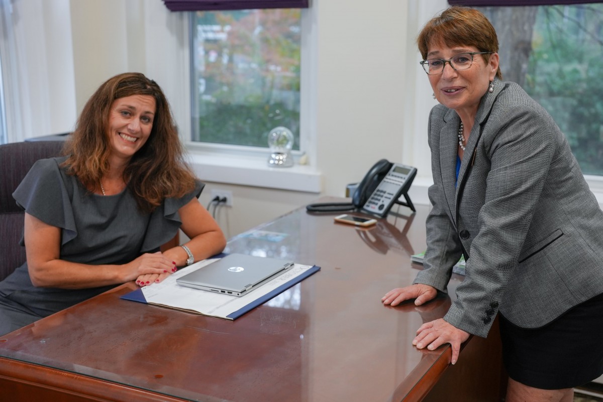 Two women in a professional office setting having a discussion.