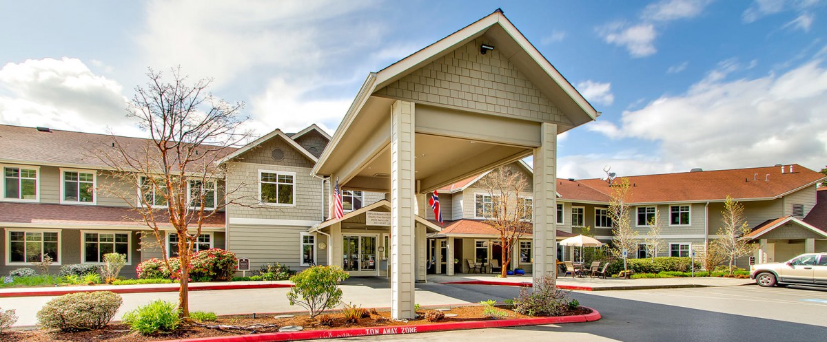 The front entrance of a modern building with large columns and a covered entryway.
