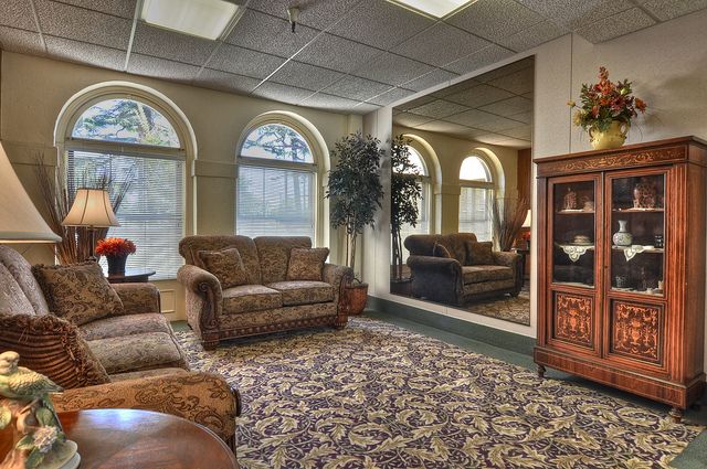 A cozy living room with sofas, a large mirror, and a television cabinet.