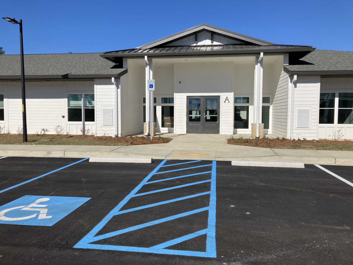 A modern building with a parking lot featuring marked handicap spaces.