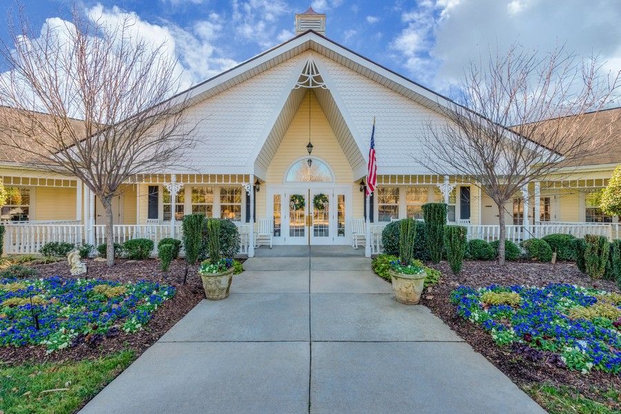 A charming white church with a neatly landscaped entrance and an American flag flying at the front.