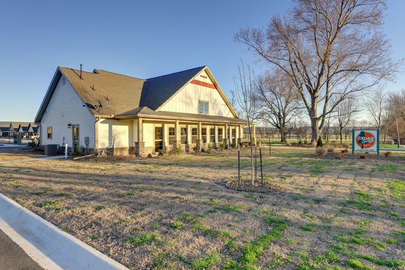 A rural countryside house surrounded by a spacious yard and trees.
