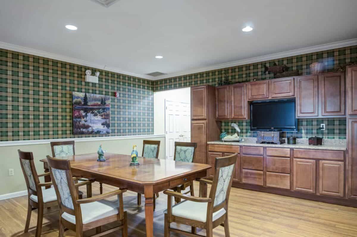 A cozy dining area with wooden furniture and cabinetry, featuring a table set for four.