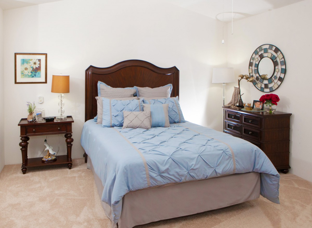 A cozy bedroom with a neatly made bed and classic furniture.