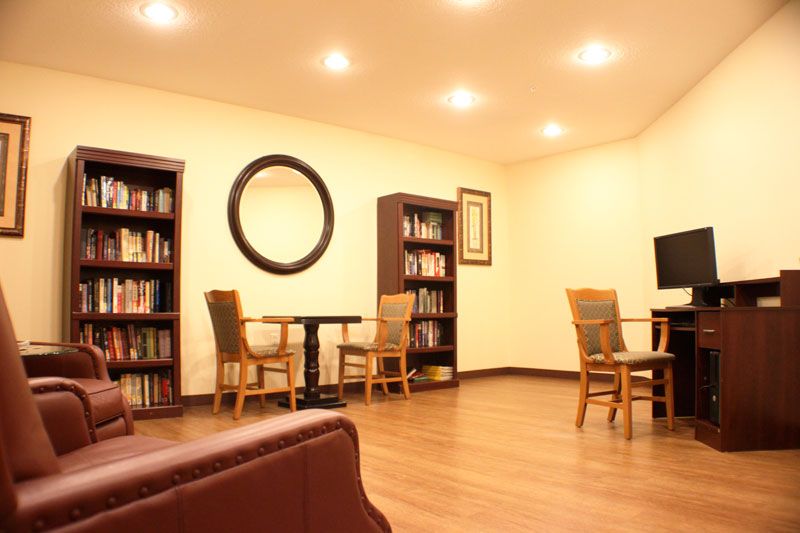 A cozy reading area with bookshelves, tables, and chairs.