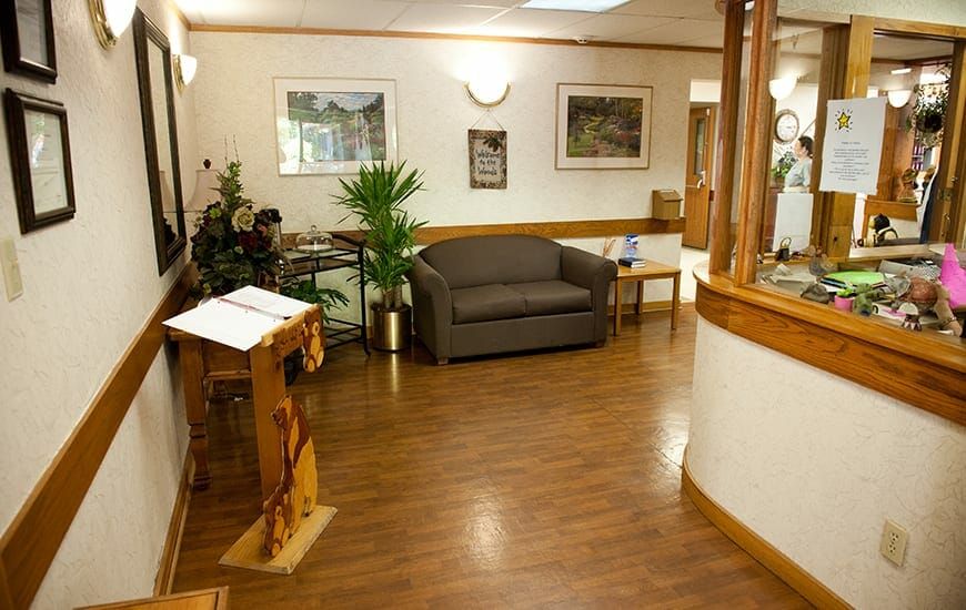 A cozy waiting room with a sofa and plants, designed for comfort.