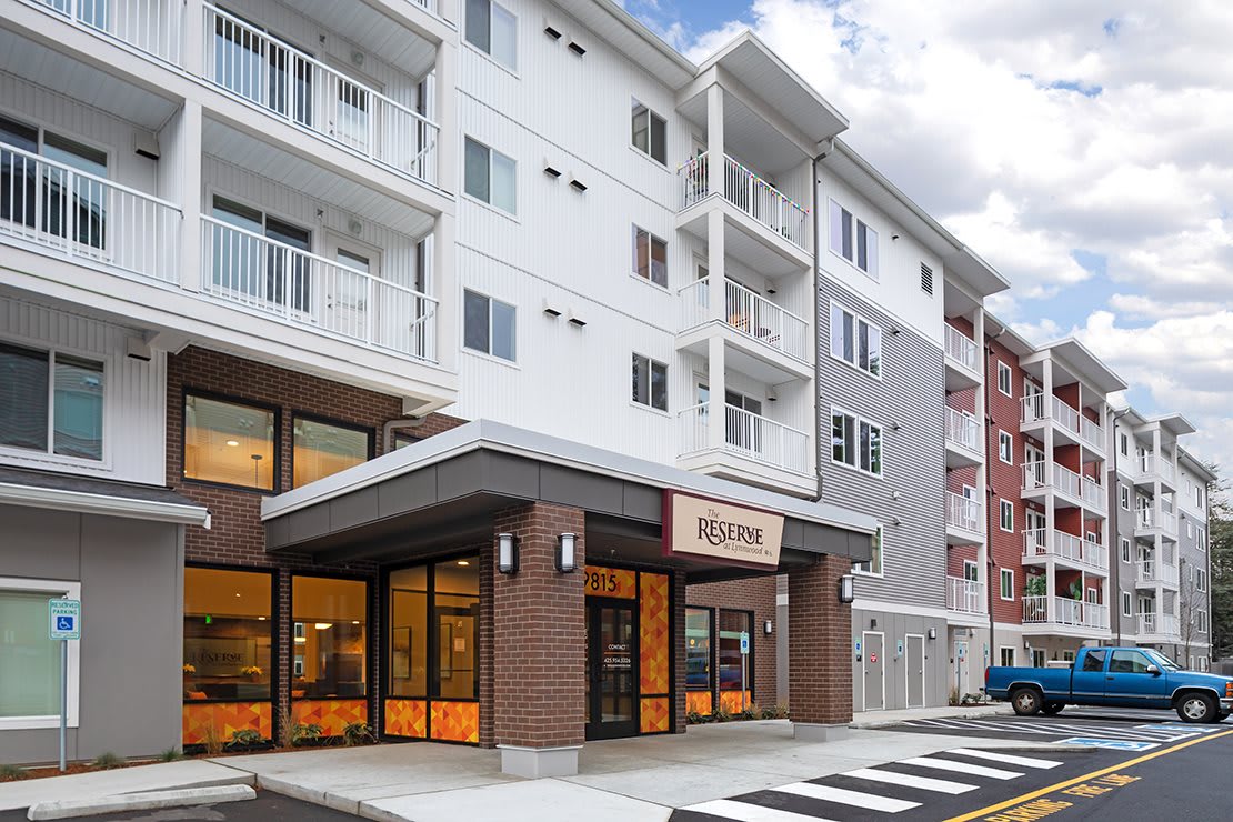 A modern multi-story building featuring a commercial storefront at street level.
