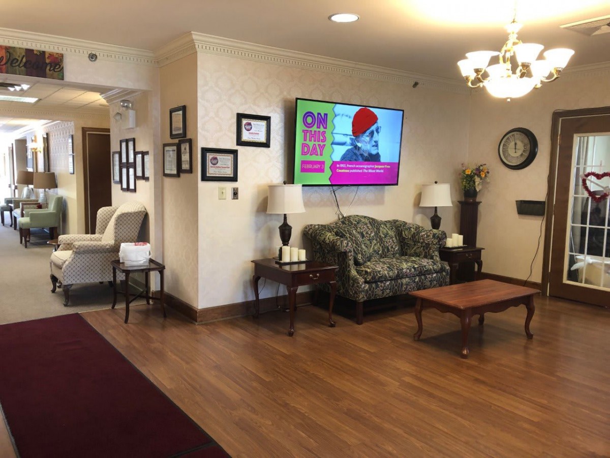 A cozy lobby area with a sofa, television, and various decorations.