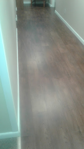 A view of a hallway with wooden flooring.