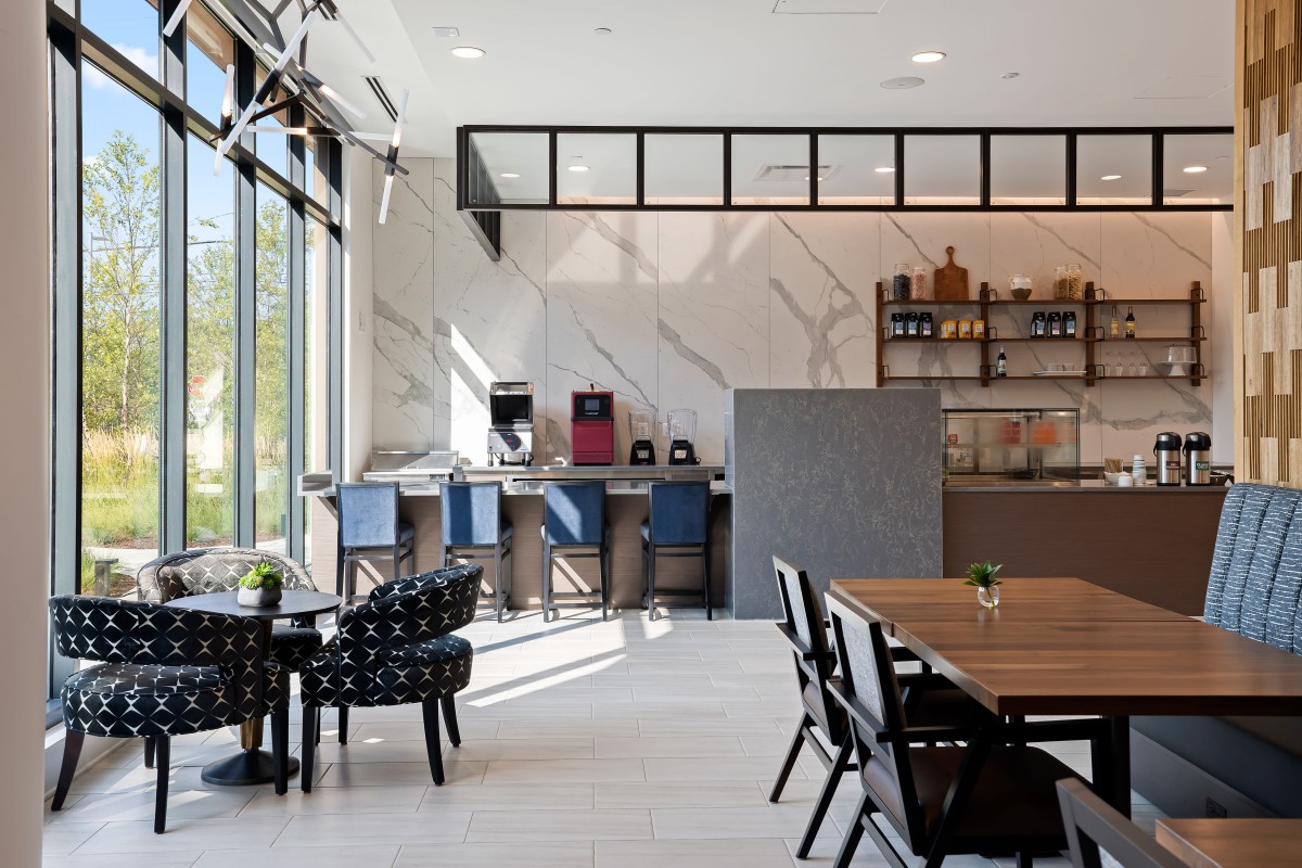 A modern cafe interior with natural light, featuring various seating options.
