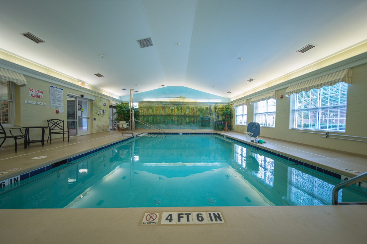 An inviting indoor swimming pool with clear water, surrounded by large windows and a serene ambiance.