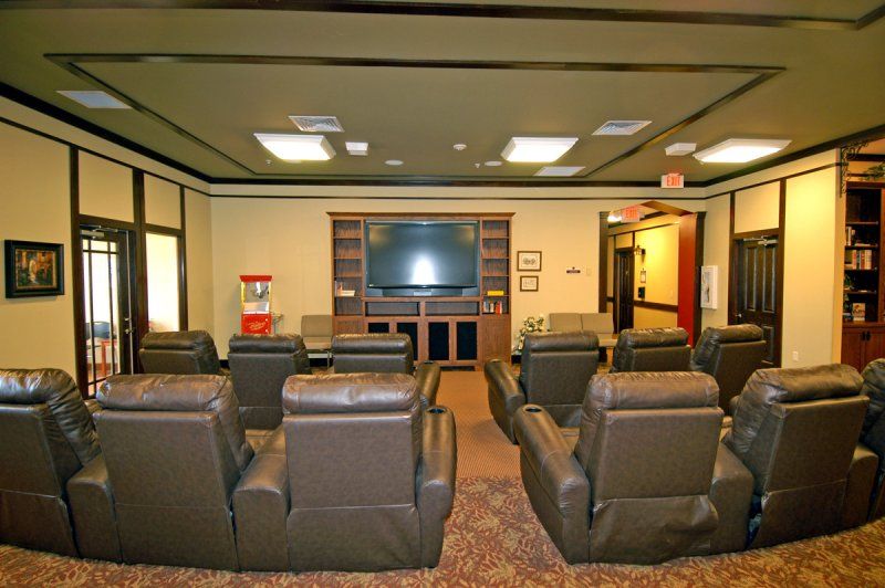 A cozy home theater room with recliner chairs and a large screen.