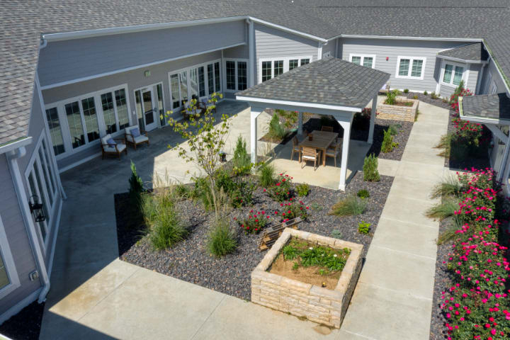 A landscaped courtyard with a pergola and raised garden beds.