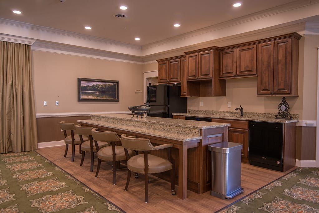 A modern kitchen interior with a large island, wooden cabinets, and seating.