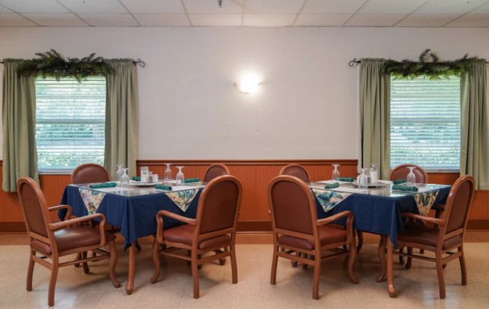 A neatly arranged dining room with tables and chairs, ready for guests.