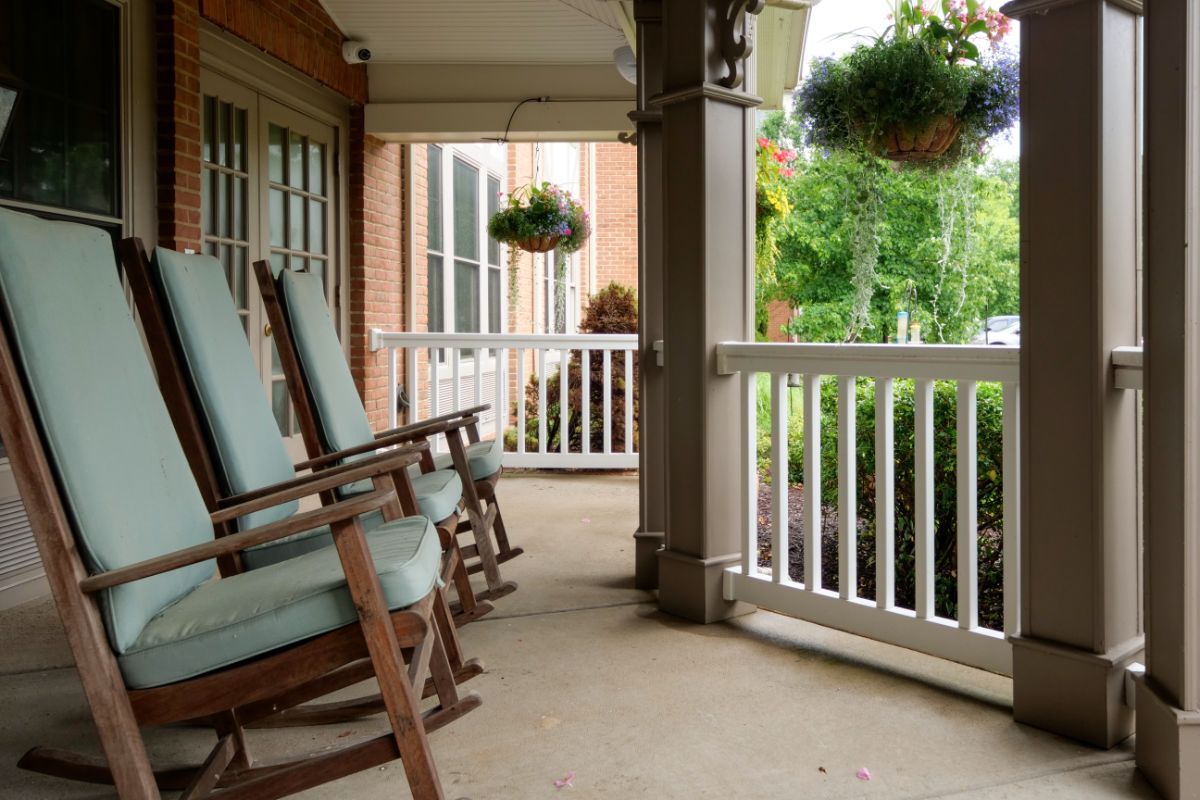 A cozy porch with rocking chairs and hanging plants, perfect for relaxation.