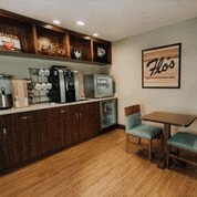 A cozy kitchenette with a coffee station, table, and chairs.