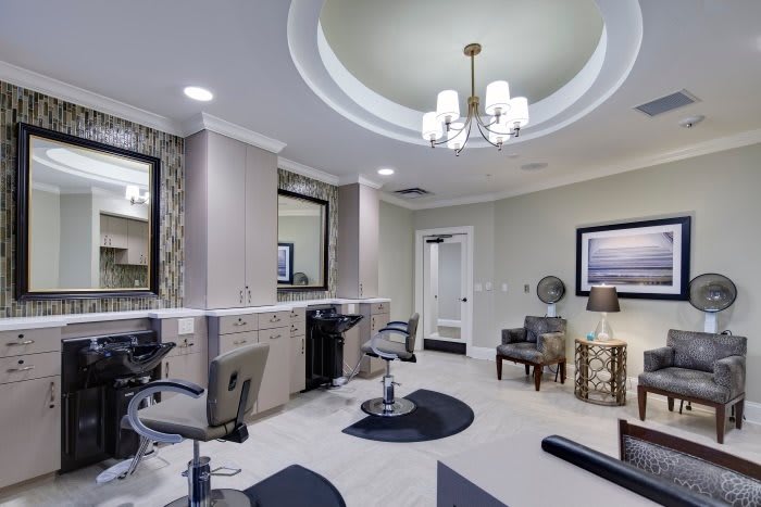 A modern salon interior featuring styling chairs, large mirrors, and elegant lighting.
