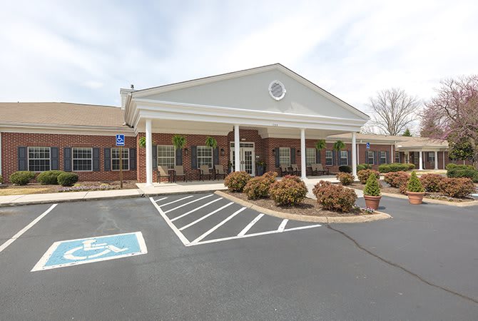 A building with a front entrance and attached parking lot featuring accessible parking spaces.
