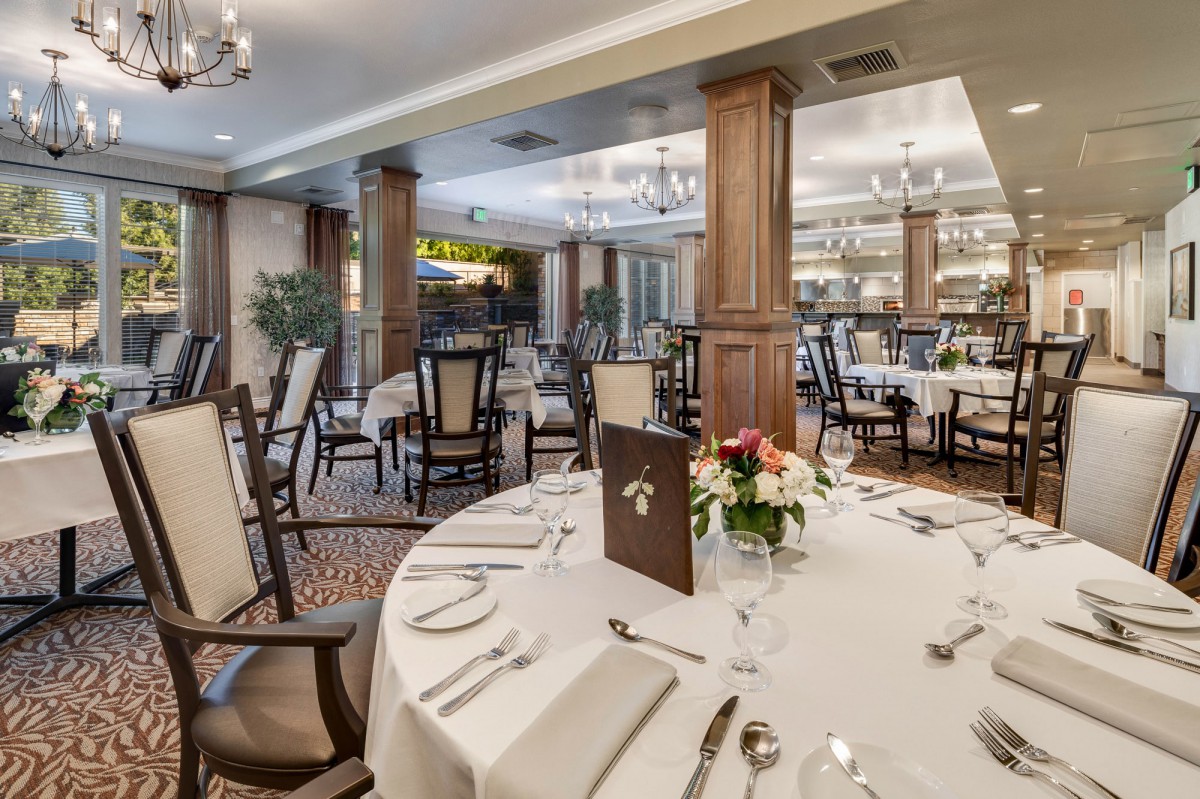 An elegantly set dining room in a restaurant with neatly arranged tables and decor.