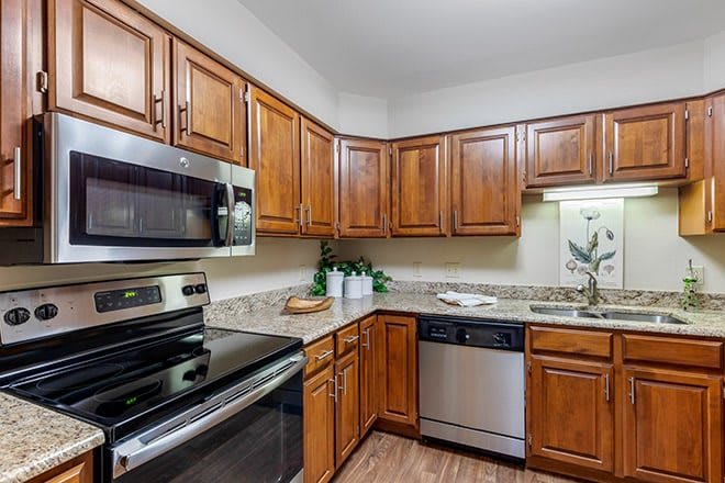 A modern kitchen with wooden cabinets and stainless steel appliances.