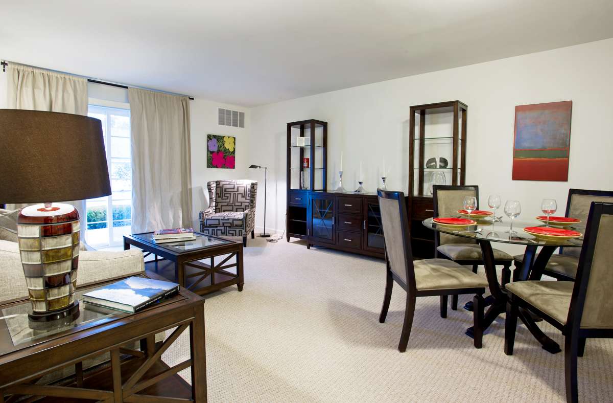 Spacious living and dining area with a glass table and elegant furnishings.