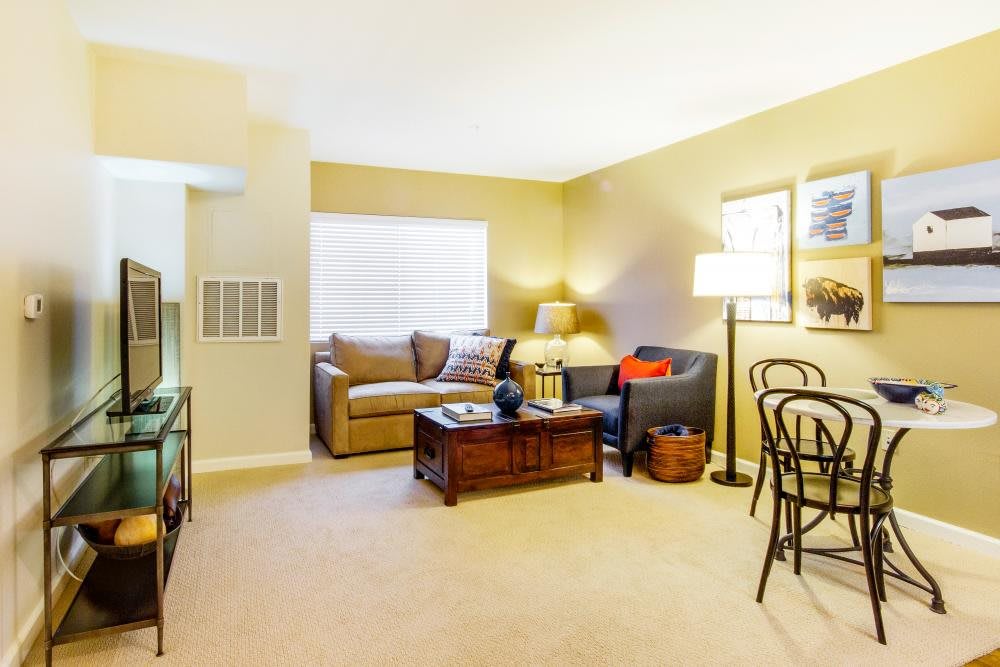 A cozy living room with a sofa, coffee table, and ambient lighting.