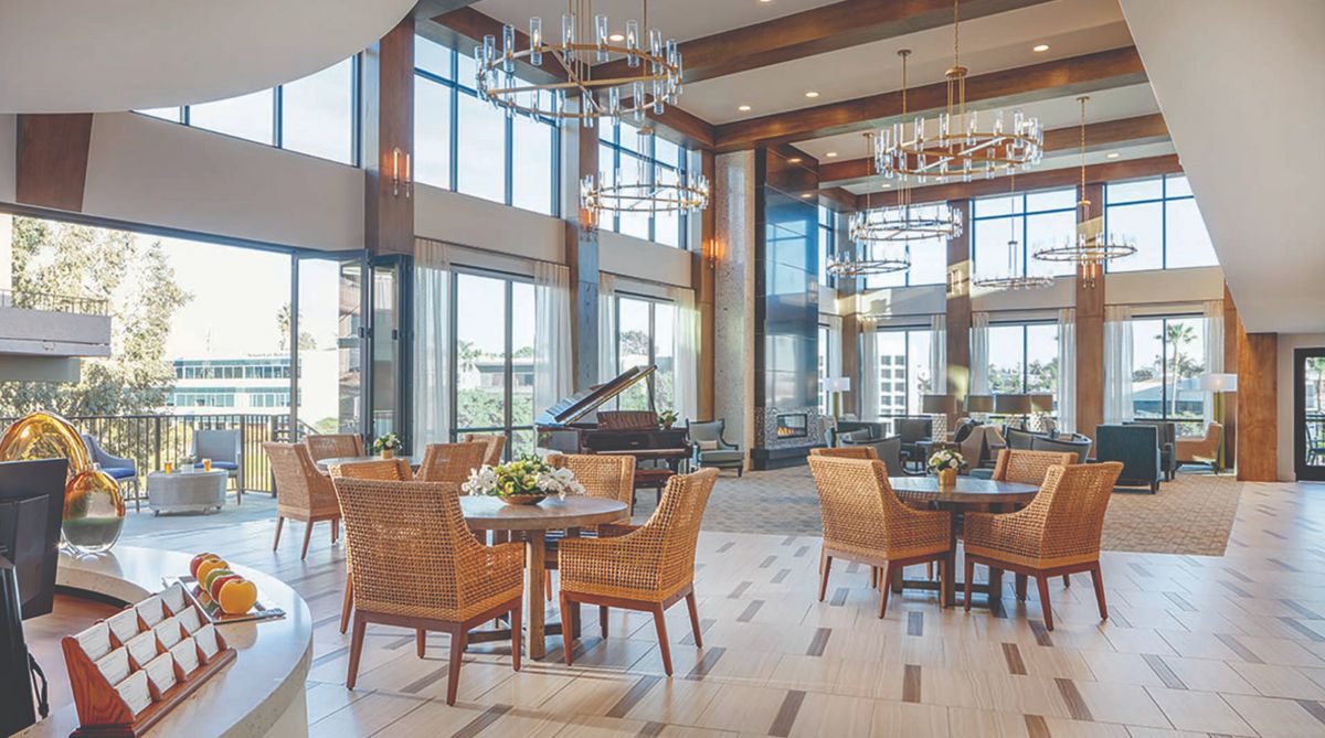 A luxurious dining area with modern decor, featuring a grand piano and large windows.