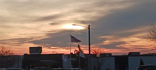 A beautiful sunset with a flag waving in the foreground.