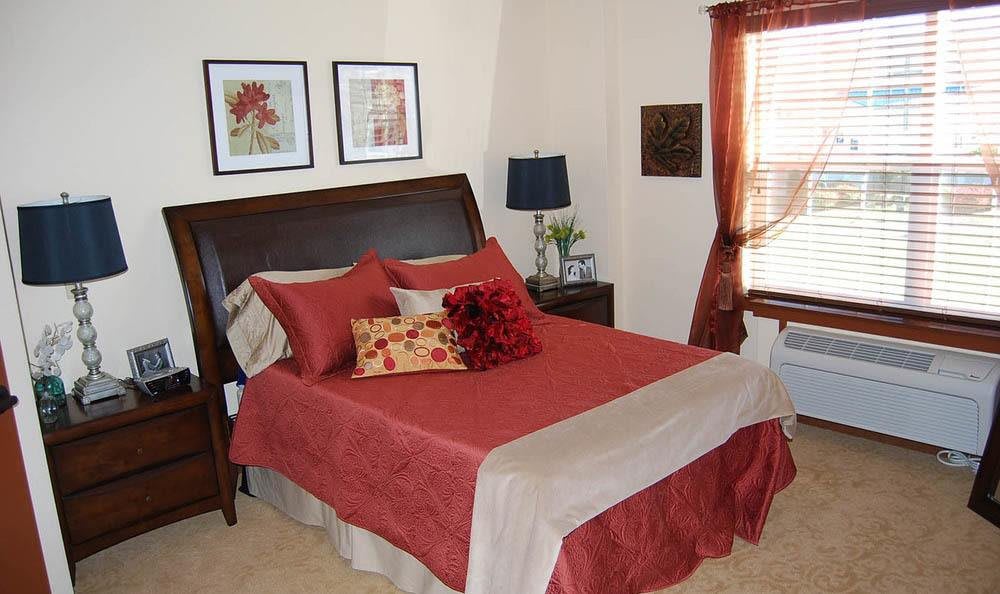 A cozy bedroom with red bedding and stylish decor.