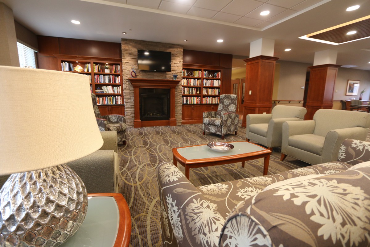 A cozy living room with bookshelves and a fireplace.