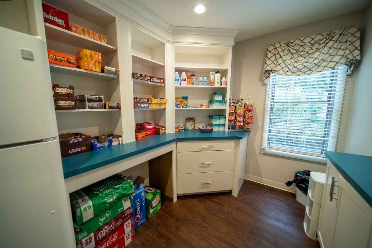 A well-organized pantry with shelves stocked with various food items and snacks.